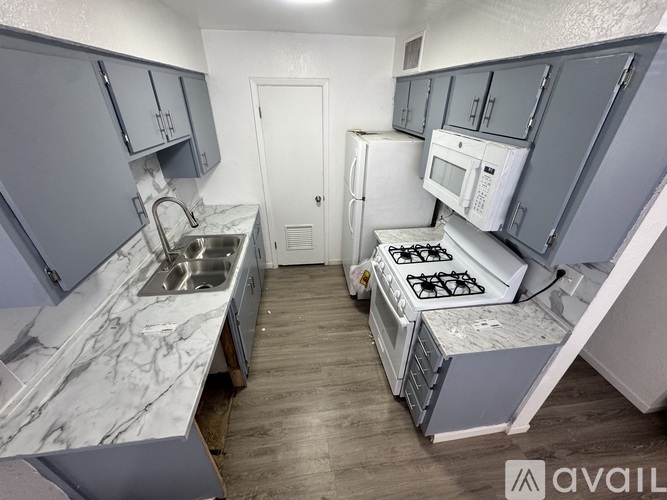 A kitchen with white cabinets and a black stove top.
