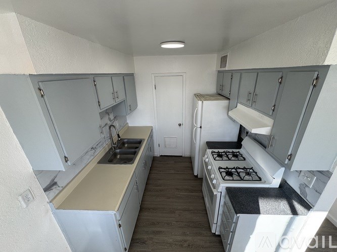 A kitchen with white cabinets and a black stove top.