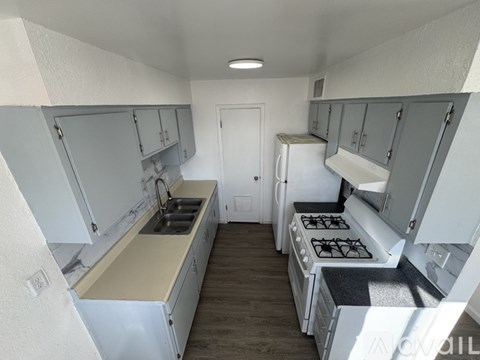 A kitchen with white cabinets and a black stove top.