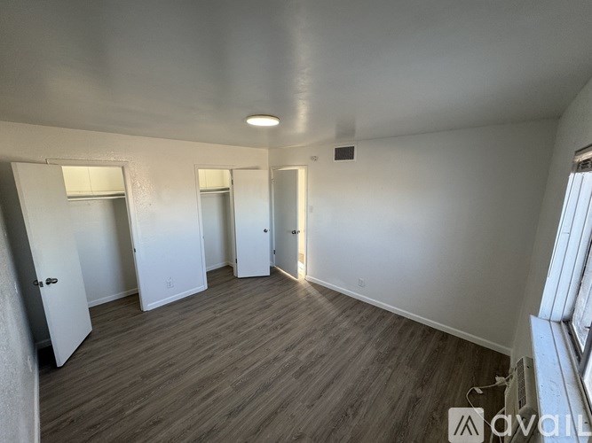 A room with wooden flooring and white walls.