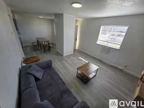 A living room with a grey couch and a wooden coffee table.
