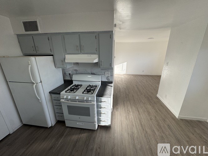 A kitchen with a white fridge and a white stove top oven.