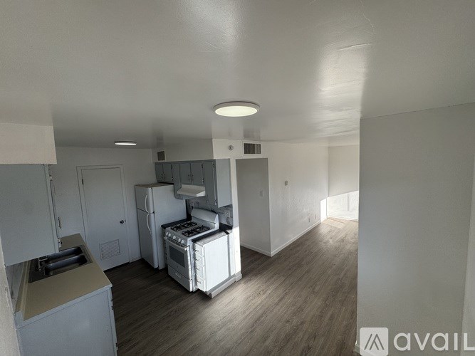 A kitchen area with a fridge, oven, and microwave.