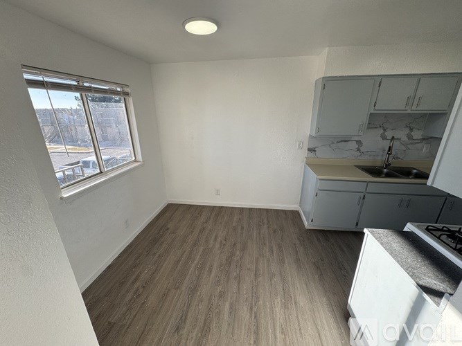 A kitchen area with a stove top oven and cabinets.