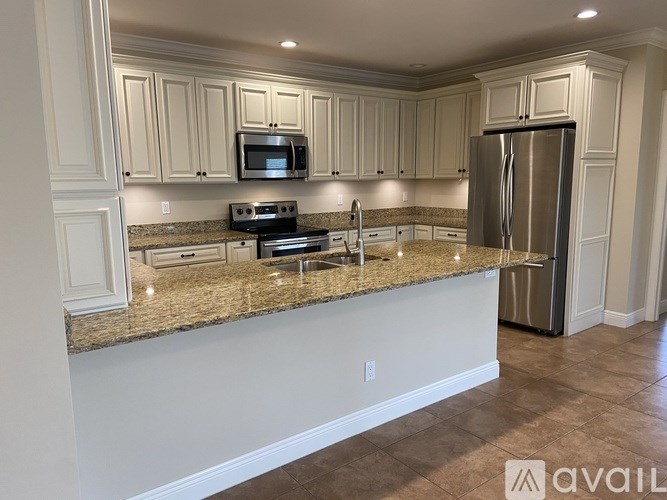 A kitchen with granite countertops and white cabinets.