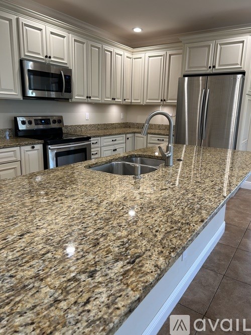 A kitchen with granite countertops and stainless steel appliances.