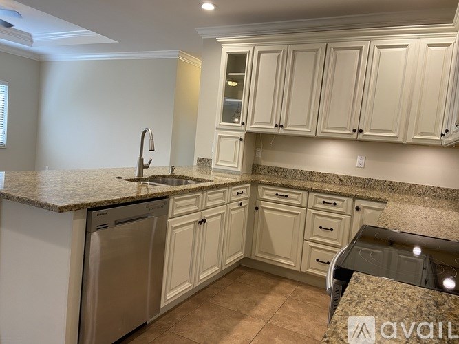 A kitchen with white cabinets and granite countertops.