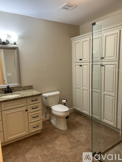 A bathroom with a toilet, sink, and shower.