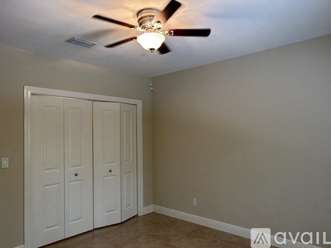 A room with a ceiling fan and two doors.