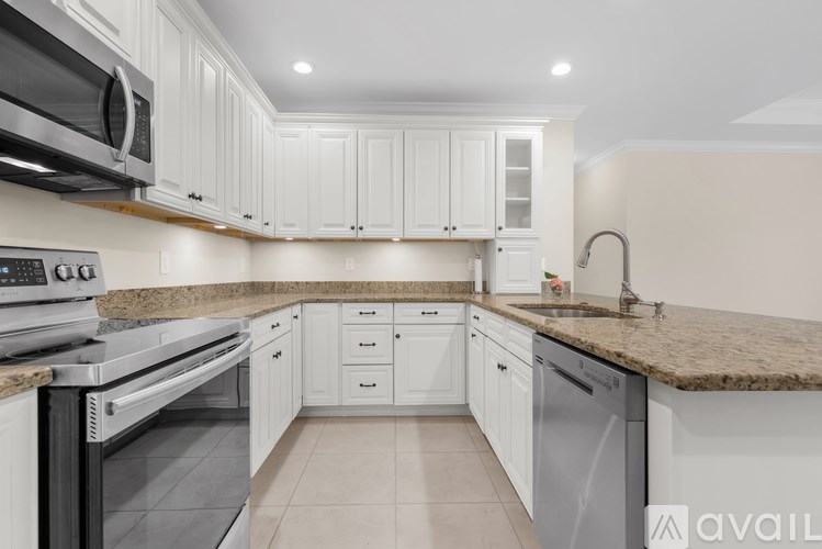 A kitchen with white cabinets and granite countertops.