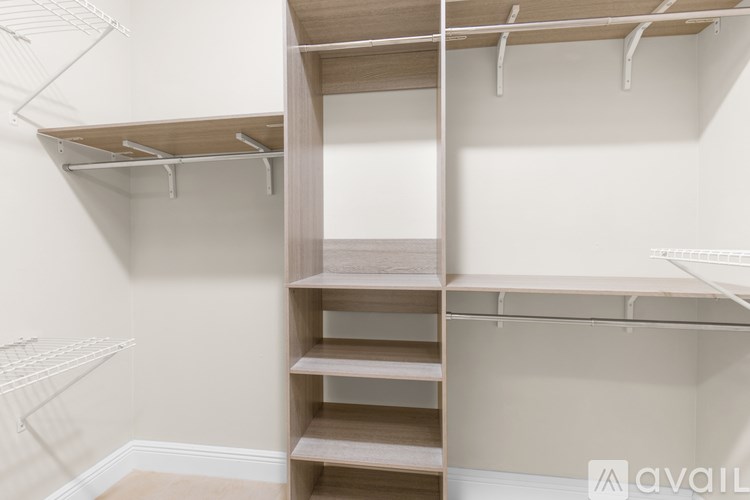 A white walk-in closet with shelves and hanging rods.