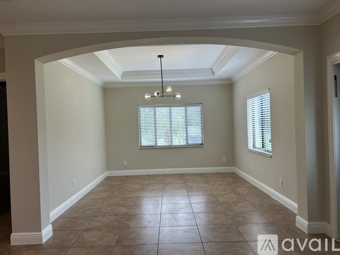 A bathroom with a toilet, sink, mirror, and cabinets.