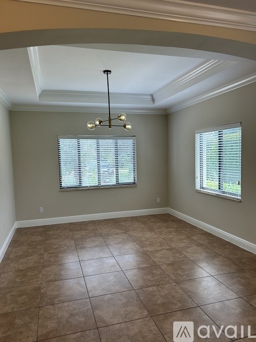 A room with a tiled floor and a chandelier hanging from the ceiling.