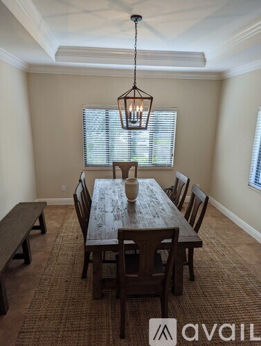 A dining room with a wooden table and chairs.