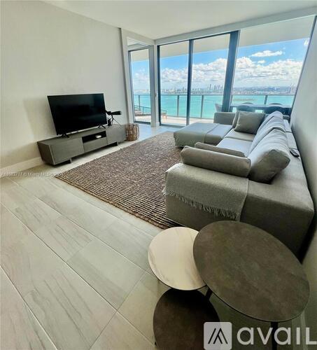 A living room with a grey couch and a television.