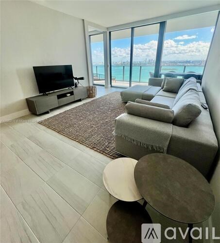 A living room with a grey couch and a television.