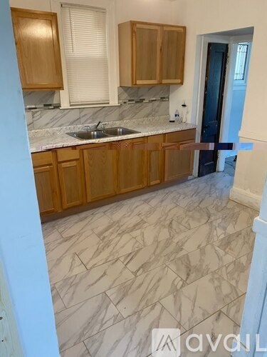 A kitchen with wooden cabinets and marble countertops.