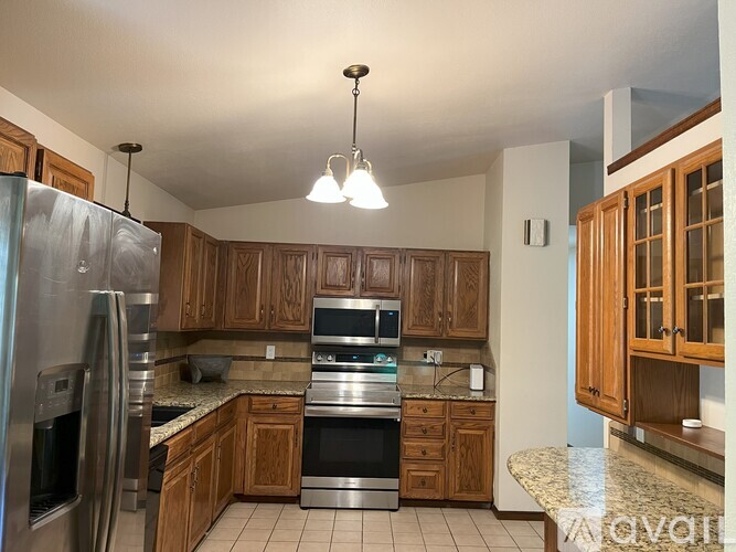 A kitchen with wooden cabinets and granite countertops.