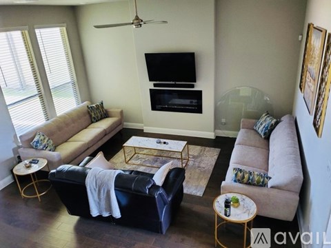 A living room with a black couch and a television.