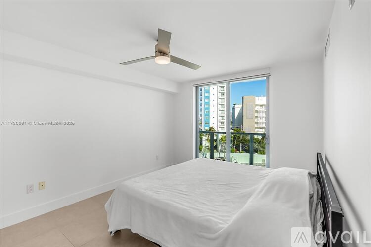 A bedroom with a large bed and a ceiling fan.