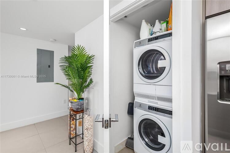 A white washing machine is in a small laundry room.