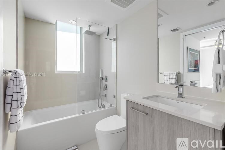 A modern bathroom with a glass shower enclosure and a white toilet.