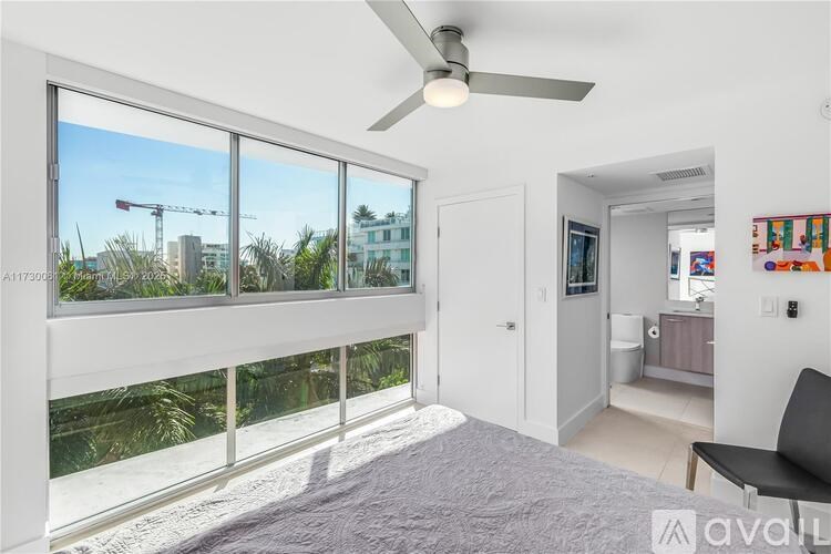 A bedroom with a large window overlooking a construction site.