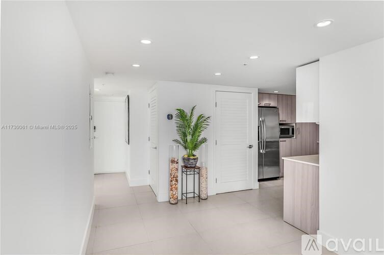 A modern kitchen with a plant on the table.