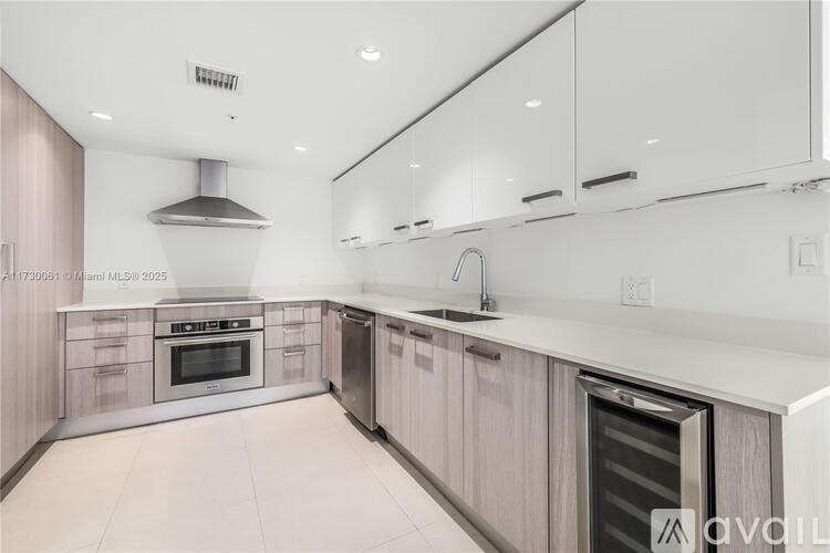 A modern kitchen with a stainless steel oven and a range hood.