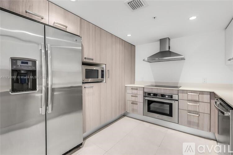 A modern kitchen with stainless steel appliances and wooden cabinets.