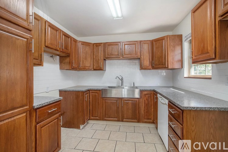 A kitchen with wooden cabinets and a marble countertop.