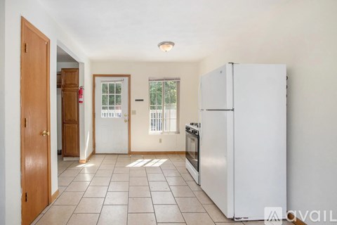 A kitchen with a refrigerator, oven, and a window.