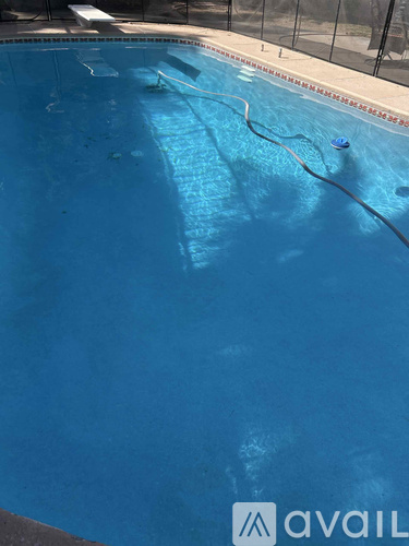 A pool with a black fence and a chair.