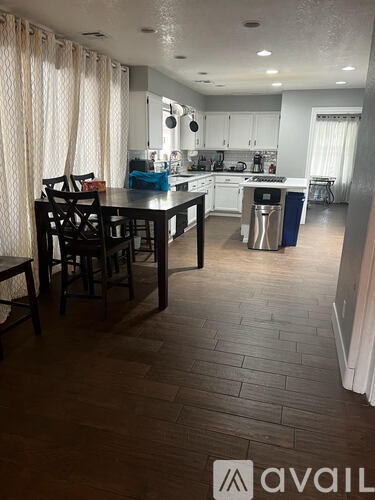 A kitchen with a dining table and chairs.