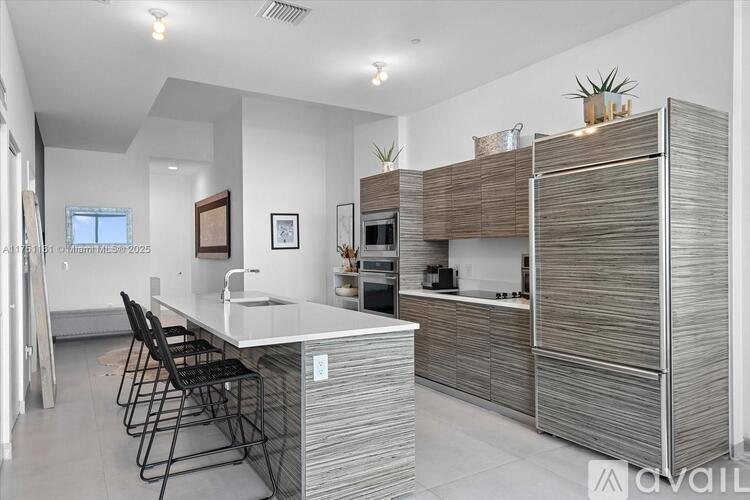 A modern kitchen with a white countertop and a sink.