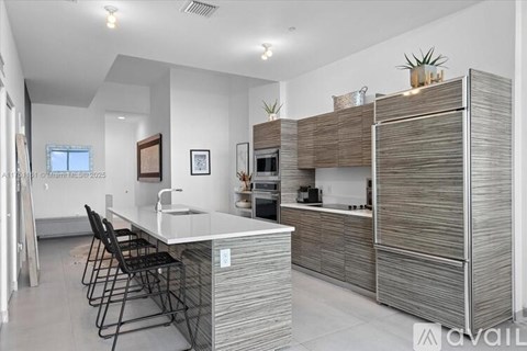 A modern kitchen with a white countertop and a sink.