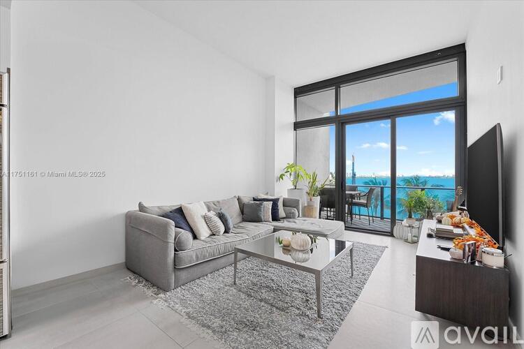 A modern living room with a grey sofa and a glass table.