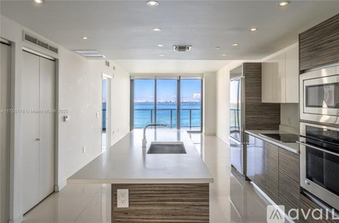 A modern kitchen with a view of the ocean.