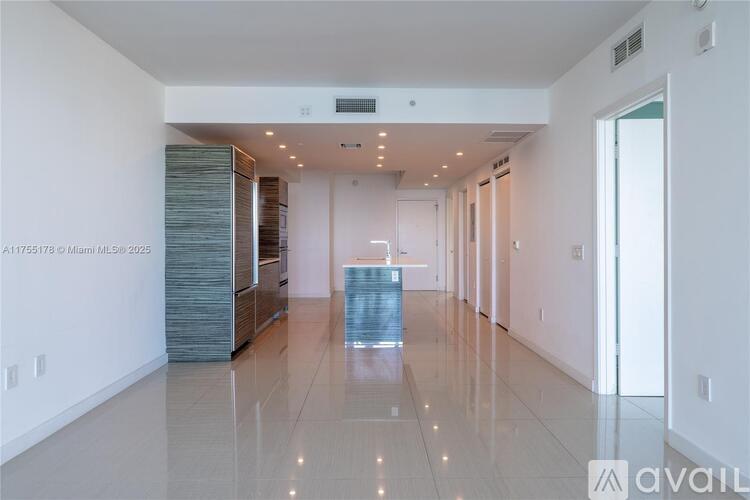 A spacious, well-lit room with a long hallway and a glass table in the middle.