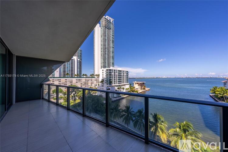 A balcony overlooks a cityscape with tall buildings and a body of water.