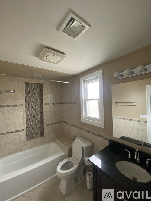 A bathroom with a tub, toilet, and sink.