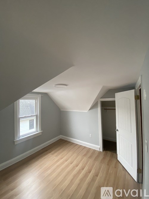 A room with a window and wooden flooring.