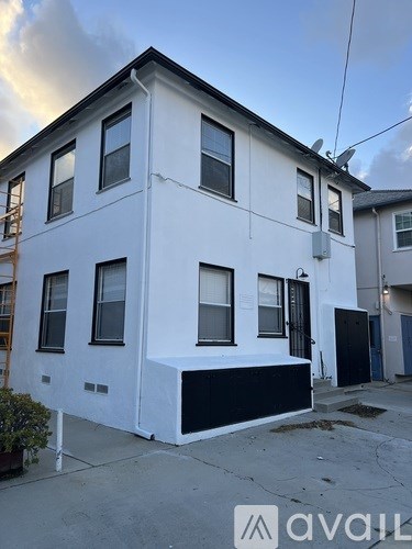 A white two-story house with a black section on the lower level.