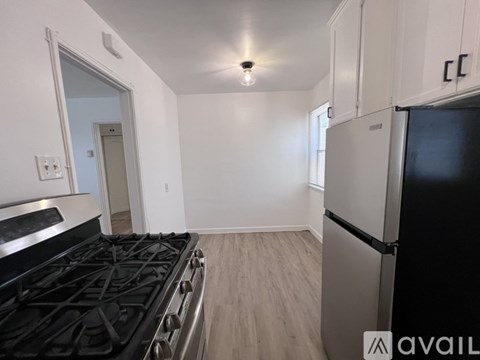 A kitchen with a black stove top oven and a black refrigerator.
