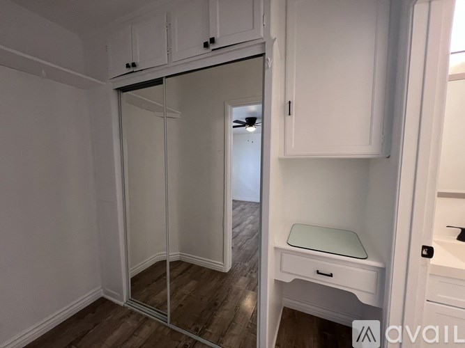 A white bathroom with a glass shower door and a white vanity.