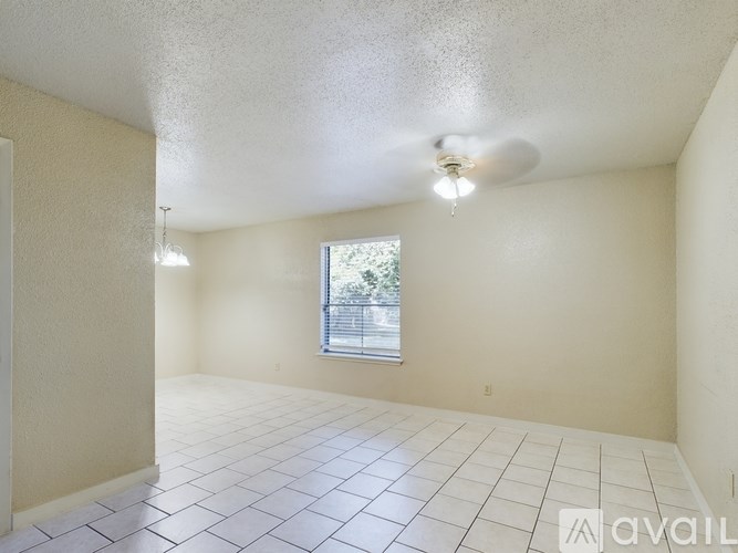 A room with a ceiling fan and a window.