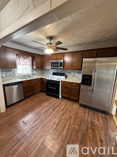 A kitchen with wooden floors and stainless steel appliances.