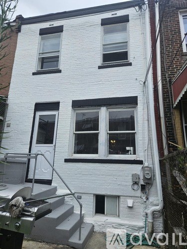 A white two-story building with black trim and windows.