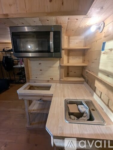 A wooden kitchen with a microwave above the sink.