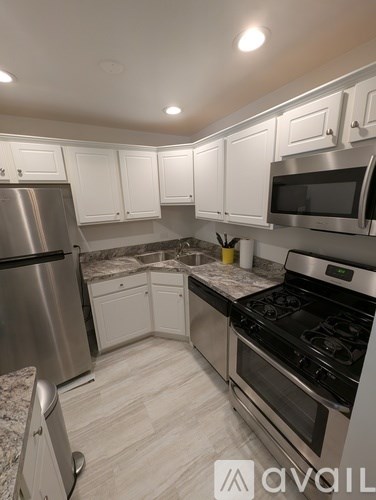 A kitchen with white cabinets and stainless steel appliances.